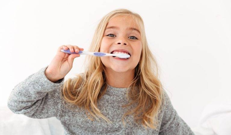 close-up-portrait-cute-kid-gray-pajamas-brushing-her-teeth-min-768x512